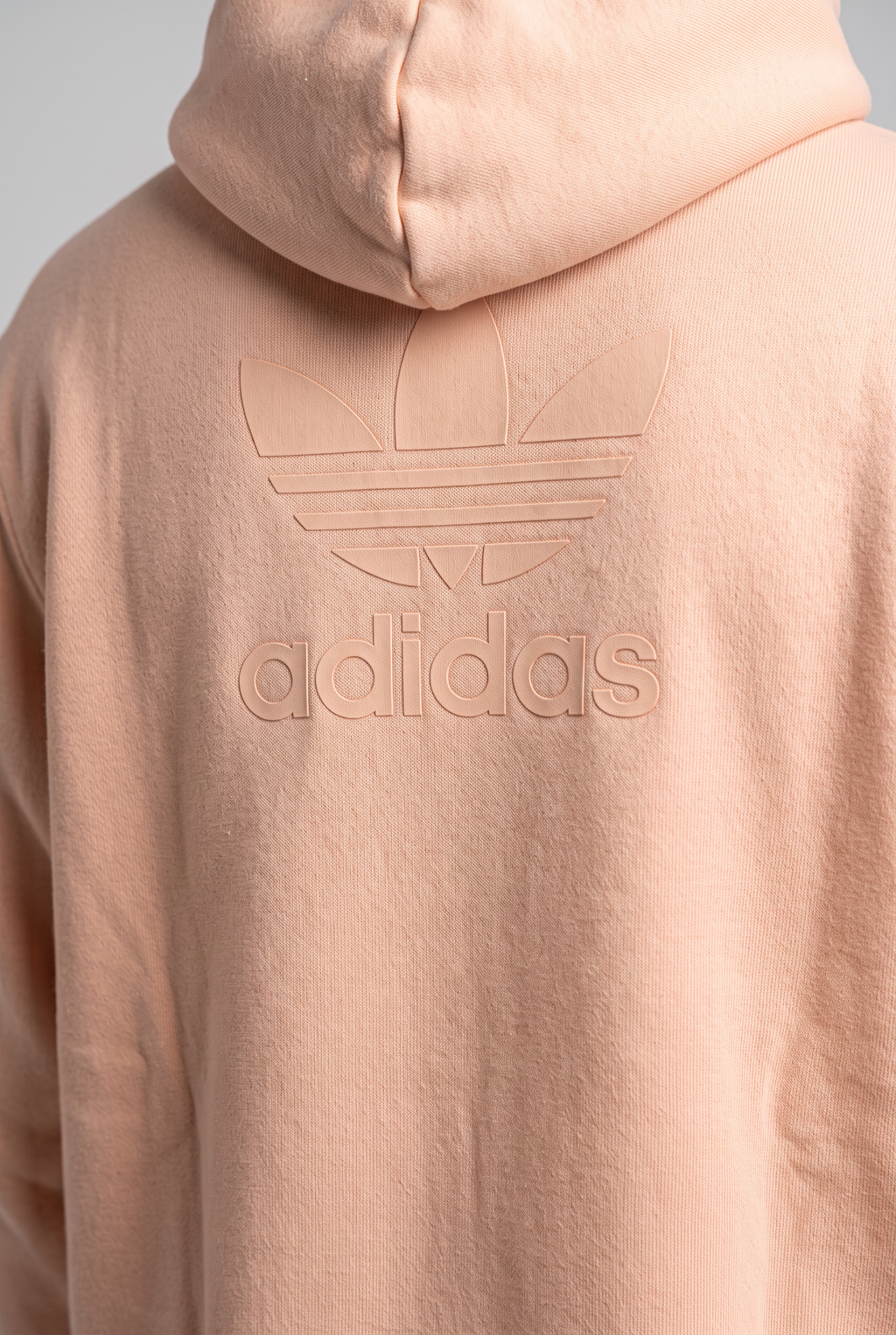 Daily Deals Outlet beige Adidas hoodie with embossed trefoil logo on the back, made from soft cotton blend sweat fabric.