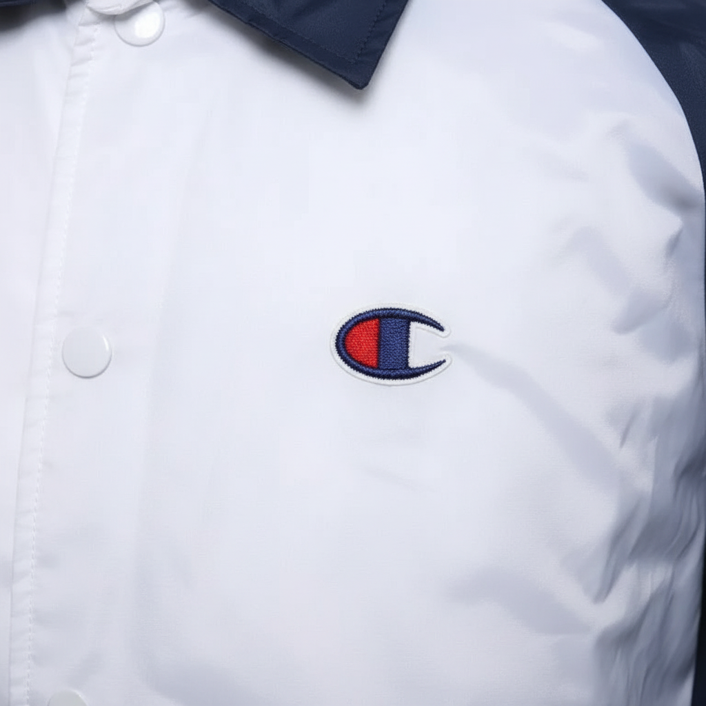 Daily Deals Outlet Champion coach jacket in white with blue collar and embroidered red, white, and blue logo detail.