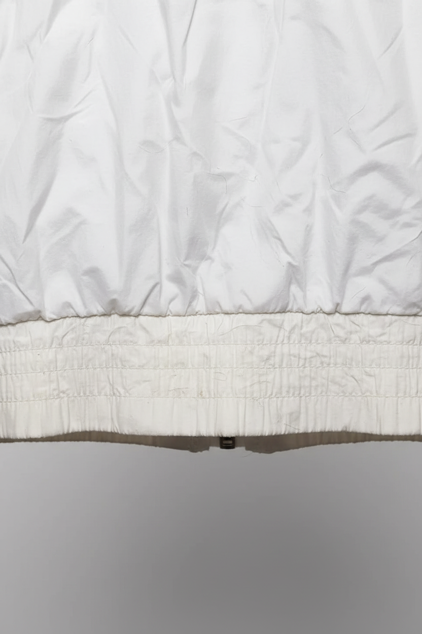 Close-up of the white ribbed hem and cotton-polyamide fabric of a Daily Deals Outlet Champion bomber jacket.